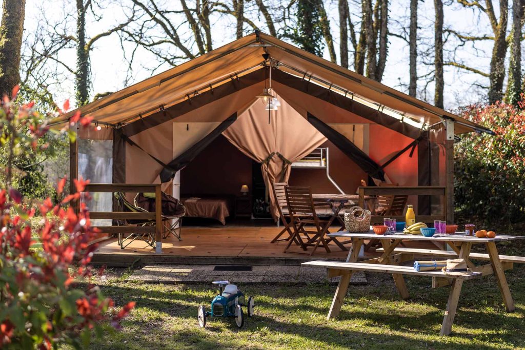 Tente lodge avec terrasse en bois et table de pique-nique au camping le Picouty