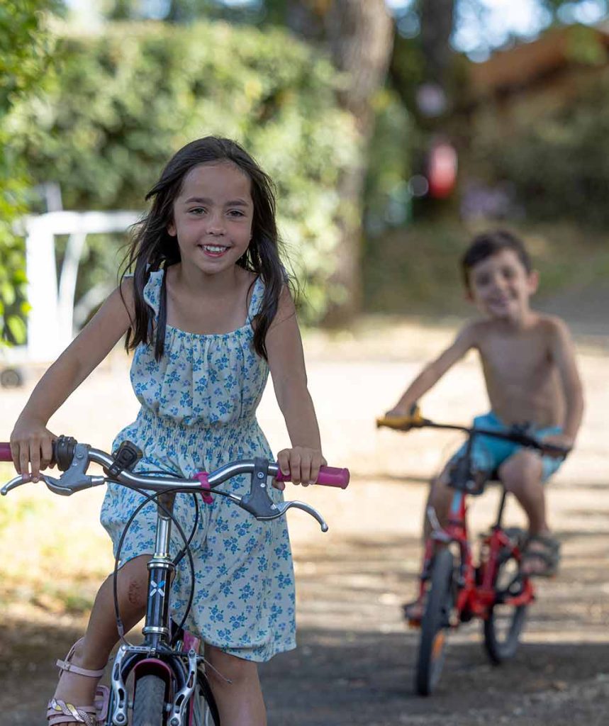 Enfants à vélo dans les allées du camping Le Picouty à Payrac
